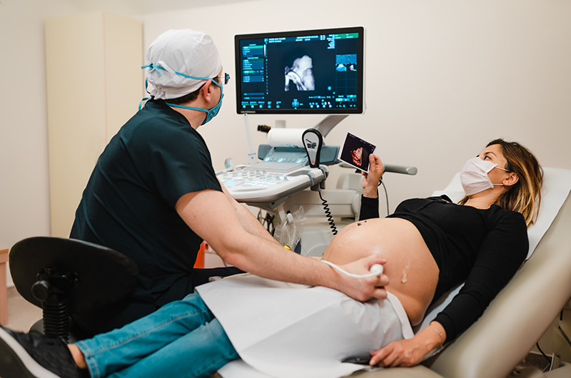 Doctor giving pregnant woman ultrasound.