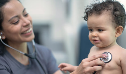A female nurse uses a stethoscope to examine a child with congenital heart defects.