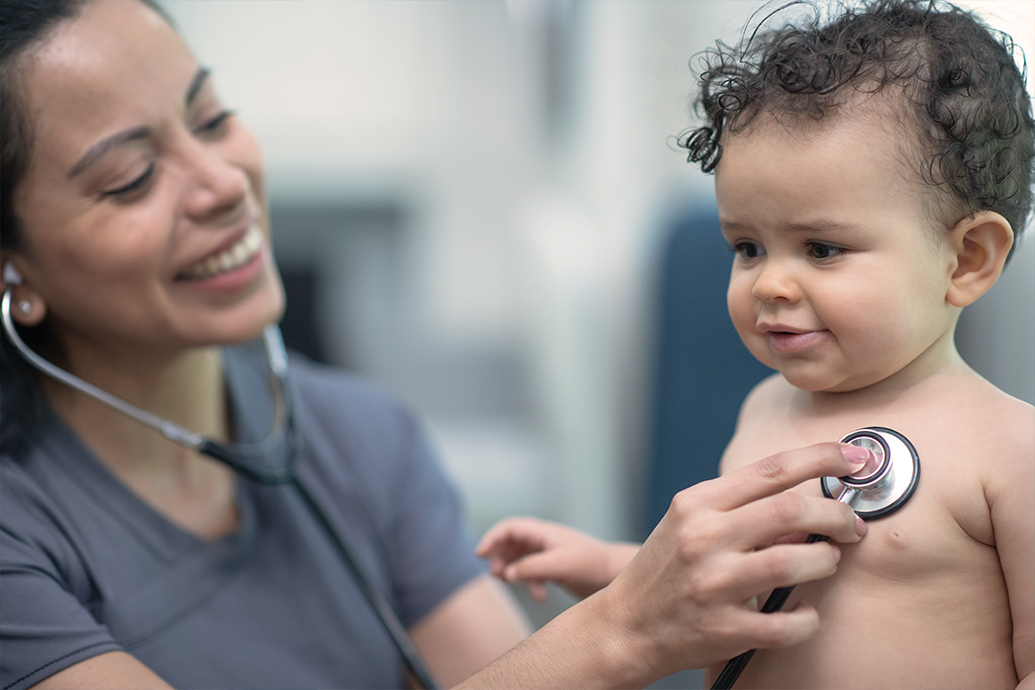 A female nurse uses a stethoscope to examine a child with congenital heart defects.