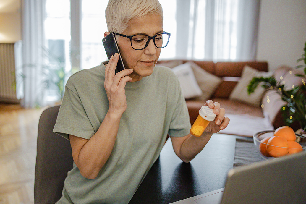 An older woman observes her medication and calls a lawyer on the phone to determine if she has received substandard care